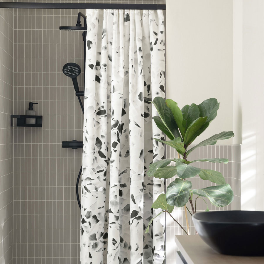 Textil-Duschvorhang Wenko Tosi mit schwarz-weiss Terrazzo-Muster aus recyceltem Polyester in moderner Dusche