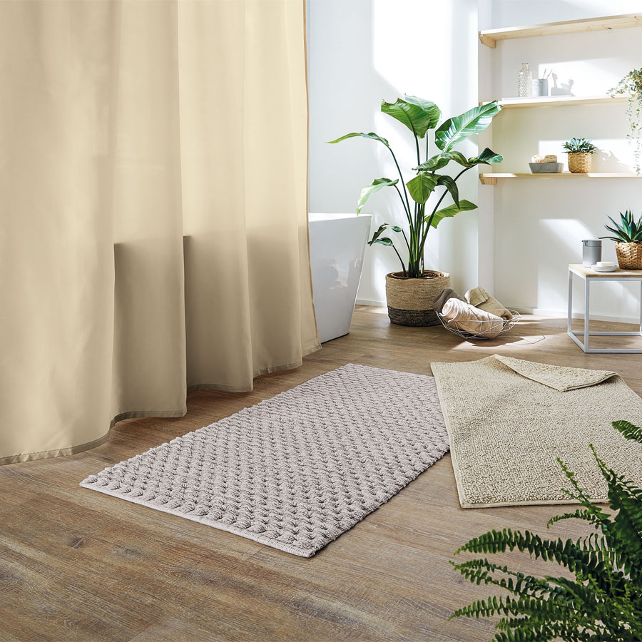 Umweltbewusst gestaltetes Badezimmer mit Duschvorhang, Badteppich und Accessoires aus &ouml;kologischen Materialien