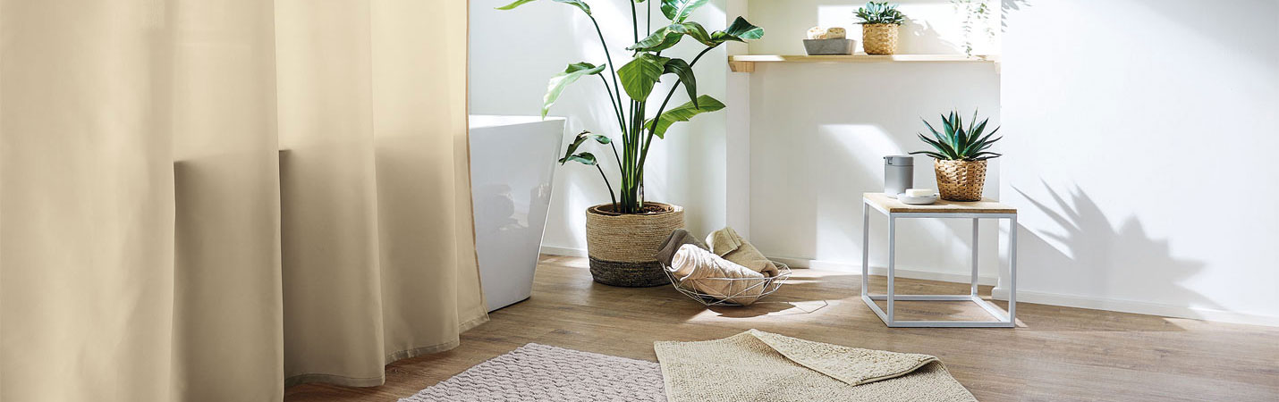 Umweltbewusst gestaltetes Badezimmer mit Duschvorhang, Badteppich und Accessoires aus &ouml;kologischen Materialien