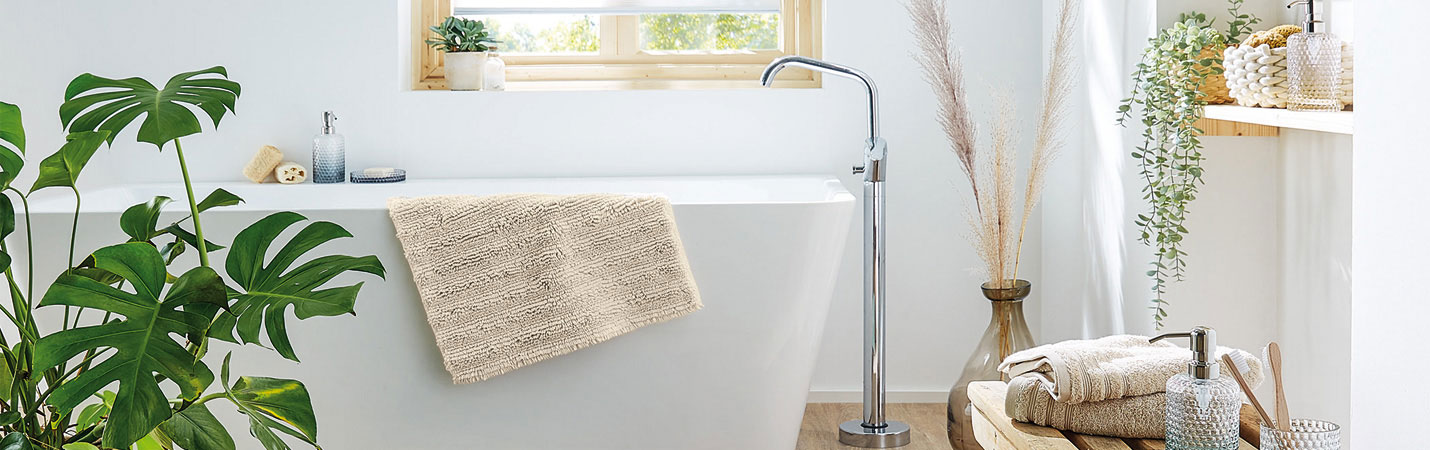 Umweltbewusst gestaltetes Badezimmer mit Badteppichen und Accessoires aus nachhaltigen Materialien